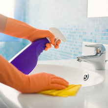 woman cleaning a bathroom sink